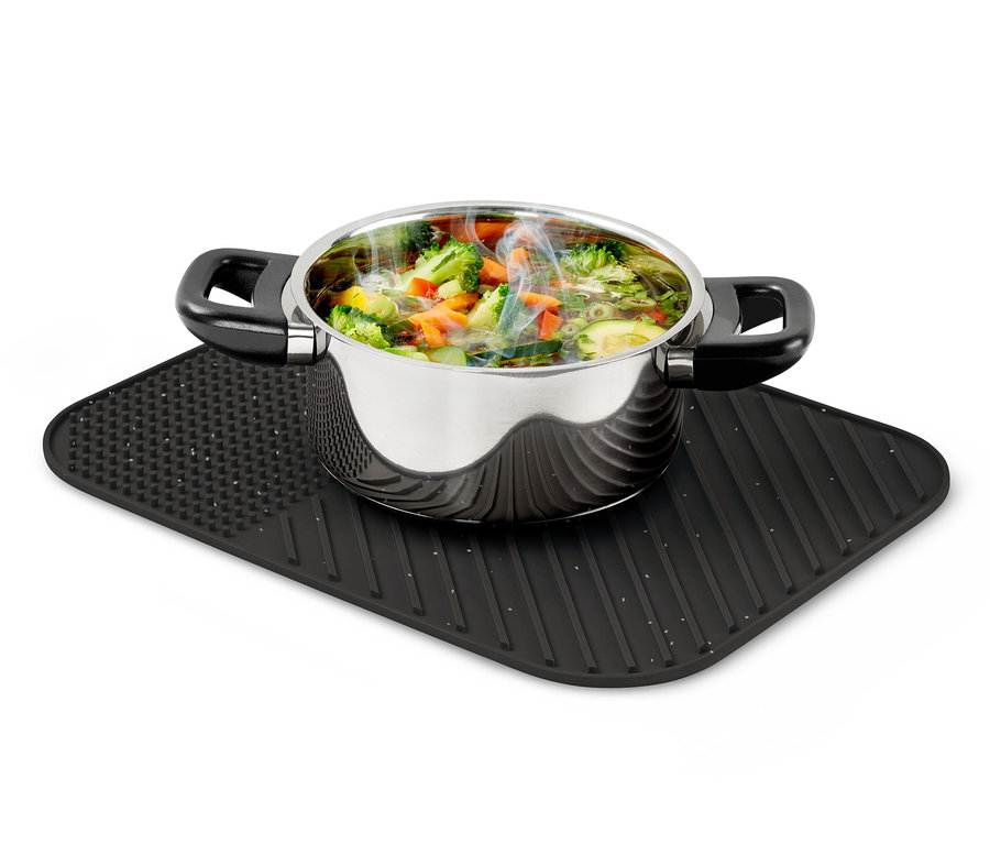 Edelstahltopf mit Gemüse steht auf einer Silikon-Abtropfmatte.