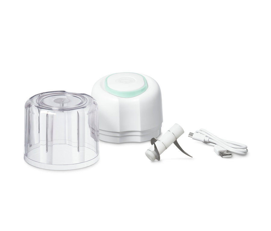 Teile des kabellosen Multizerkleinerers: durchsichtiger Behälter, weisser Motor, Messeraufsatz und Ladekabel.