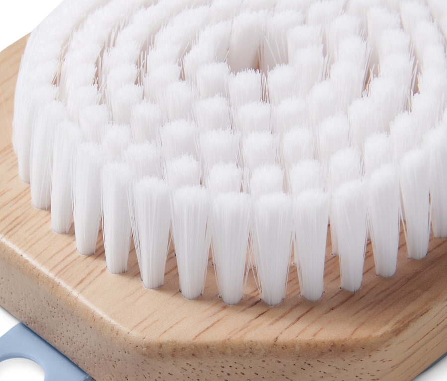 Nahaufnahme einer Gesichtsreinigungsbürste mit weißen Borsten und Holzgriff.