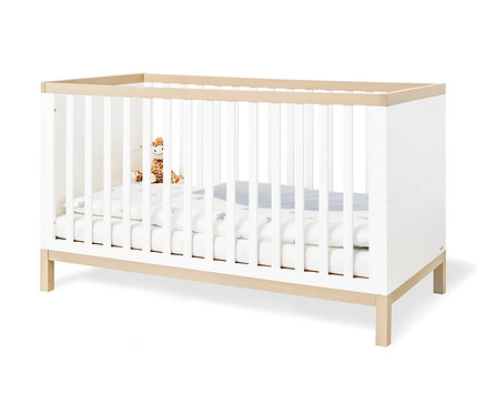 Pinolino Babybett »Light« mit weißen Gitterstäben und Holzrahmen. Im Inneren liegt eine Plüschgiraffe auf einer Decke mit Sternen.