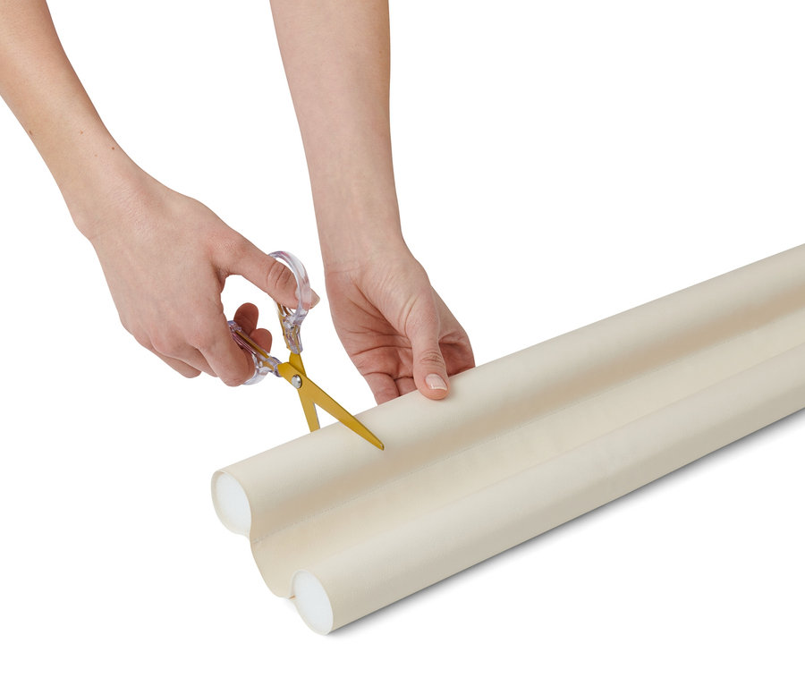 Hände schneiden eine Türboden-Doppeldichtung mit einer Schere.