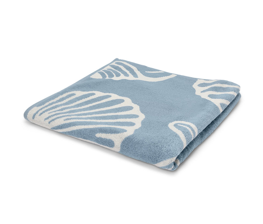 Ein gefaltetes XL-Badetuch mit Muschelmuster auf hellblauem Hintergrund.