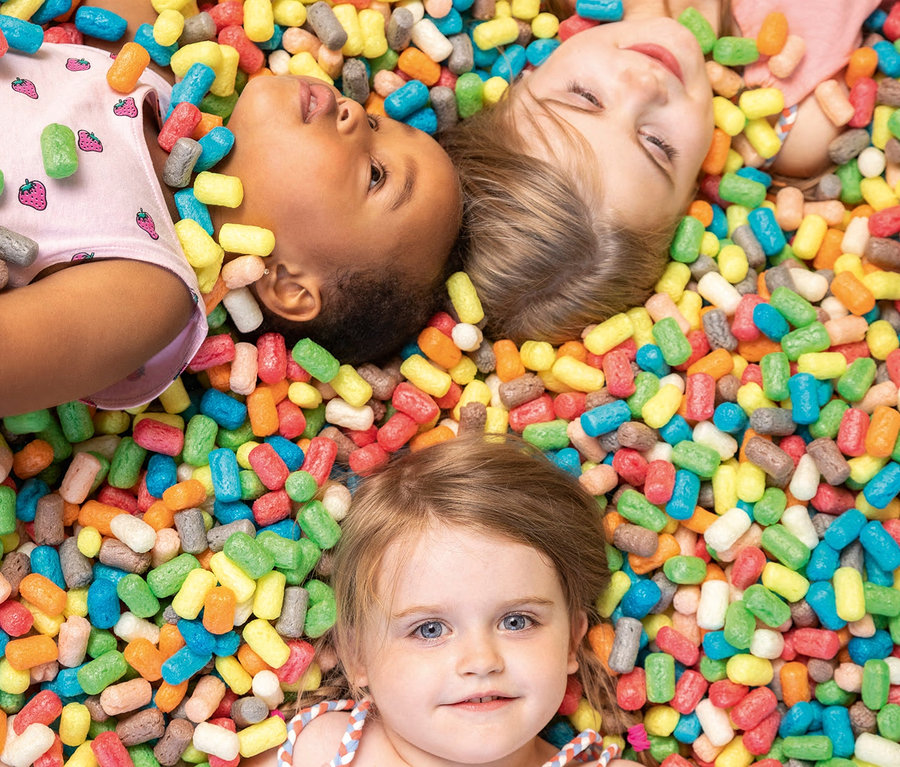 Drei Kinder liegen in einem PlayMais®-Set.