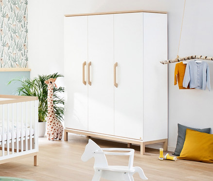 Kinderzimmer mit weißem Gitterbett, großem Pinolino Schrank Light und Spielzeug.