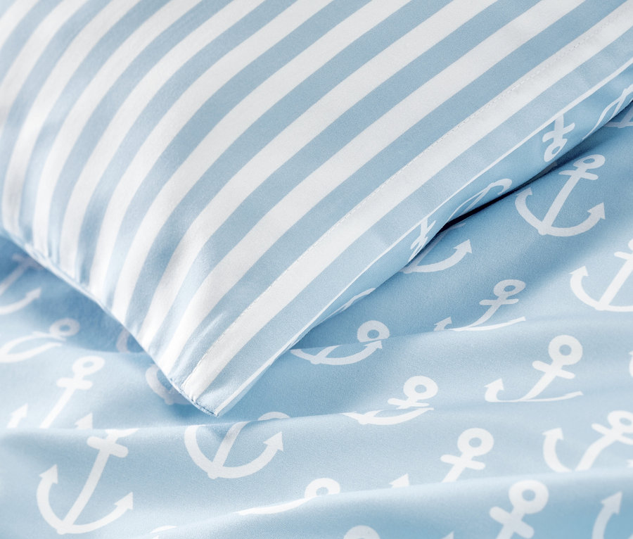 Detailansicht von blau-weisser Microfaser-Bettwäsche, Normalgröße, mit Anker-Motiv und gestreiftem Kissen.
