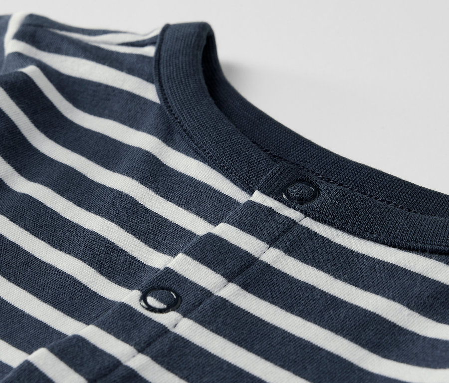 Detailaufnahme eines Baby-Sets, blau-weiß gestreift, mit Druckknöpfen.
