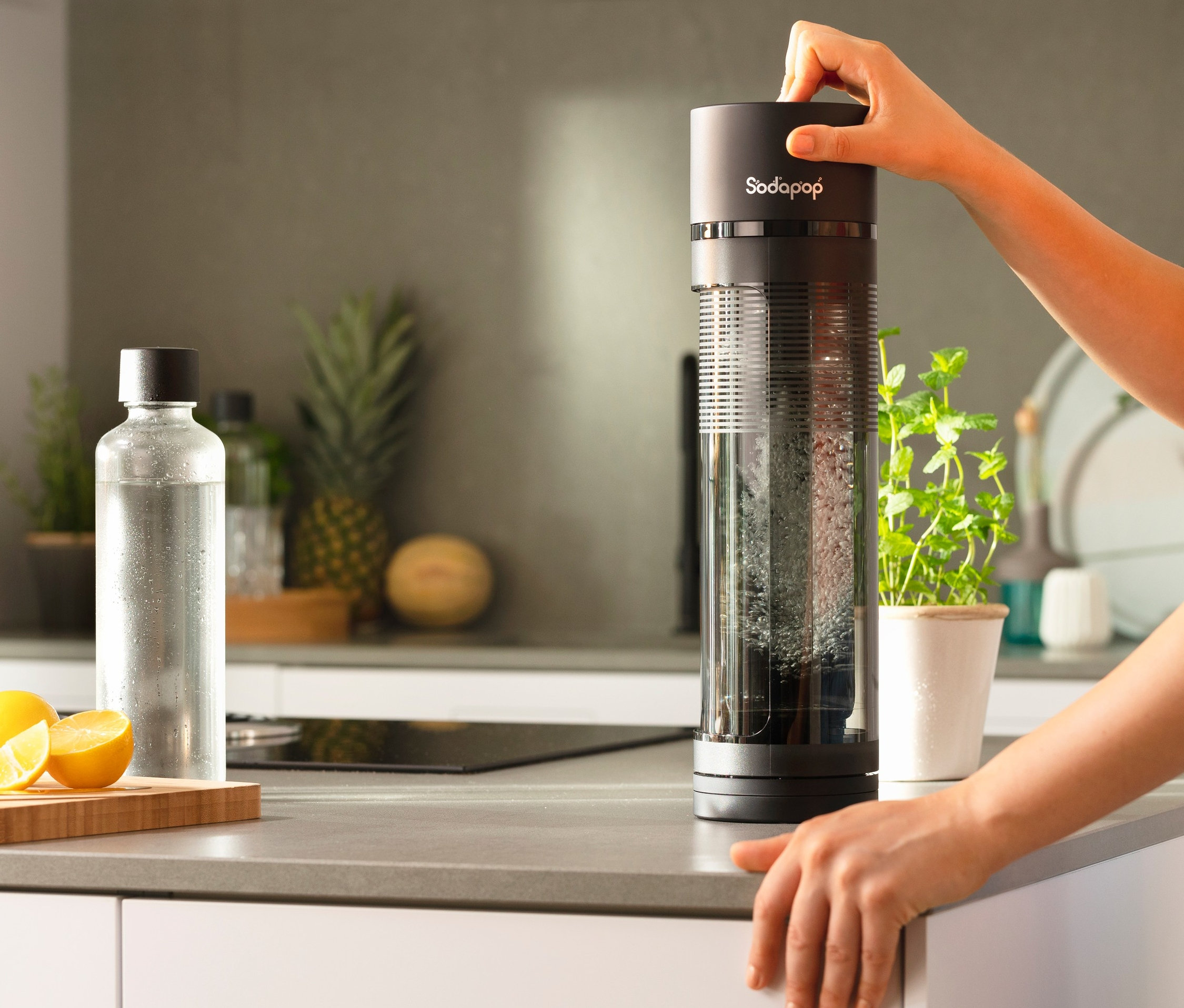 Frau bedient Sodapop Wassersprudler »Logan« in Küche.