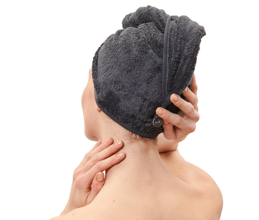Frau befestigt Turban-Handtuch, anthrazit, am Kopf.