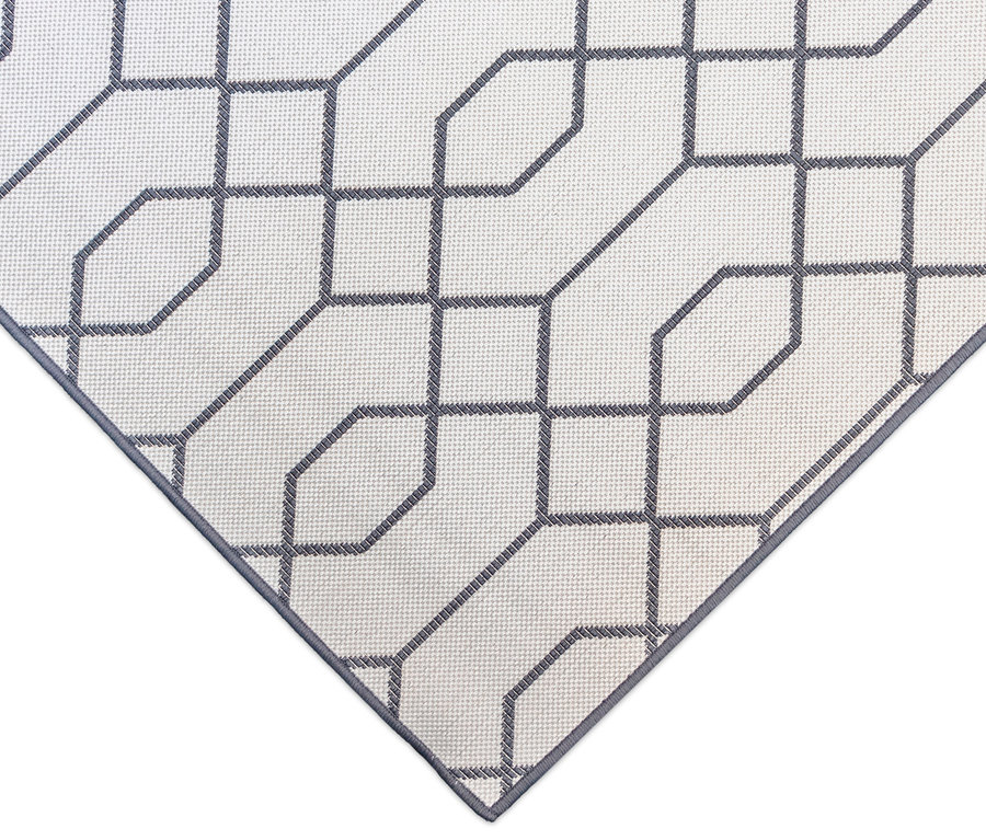 Detailansicht eines grau-weißen Outdoor-Wendeppichs "Geo River" mit geometrischem Muster.