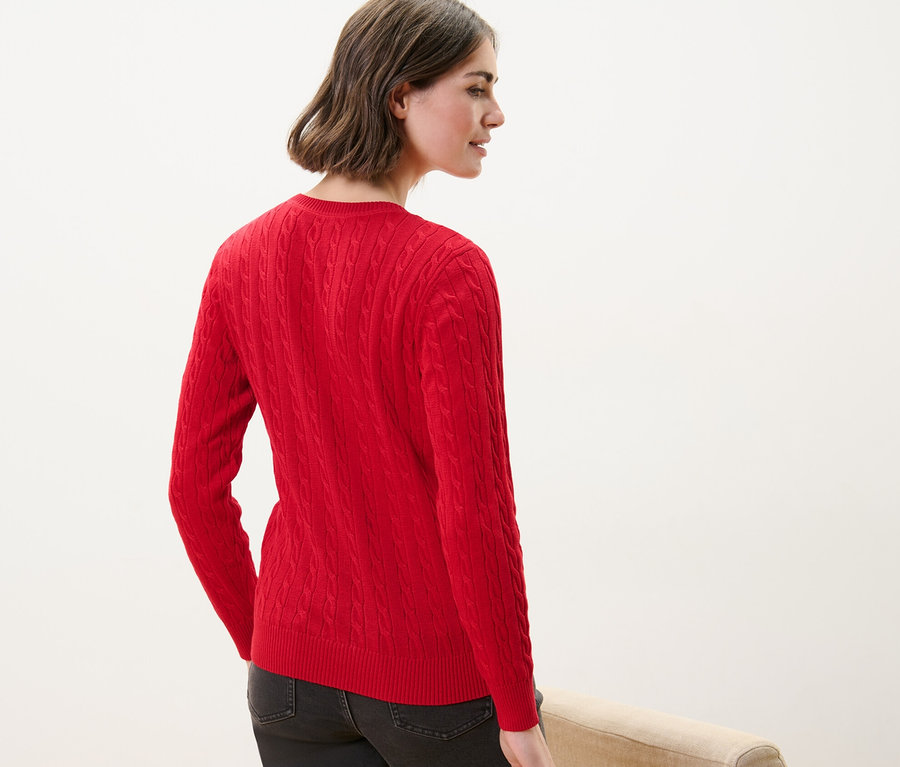 Frau von hinten trägt einen roten Zopfstrickpullover.