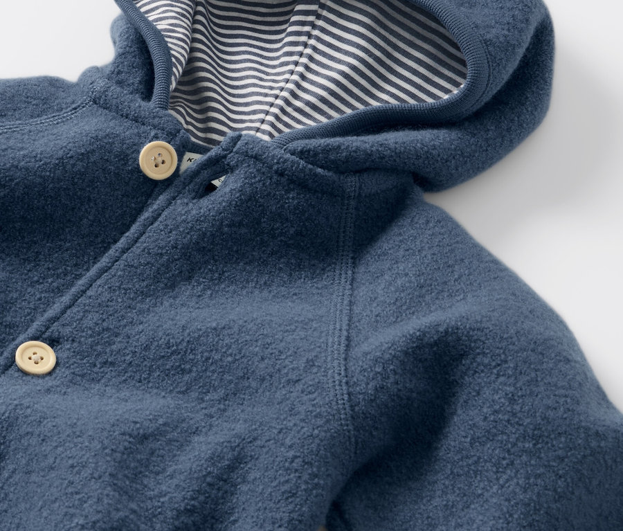 Detailansicht des blauen Baby-Walkoveralls mit Merinowolle, Kapuze und Knöpfen.