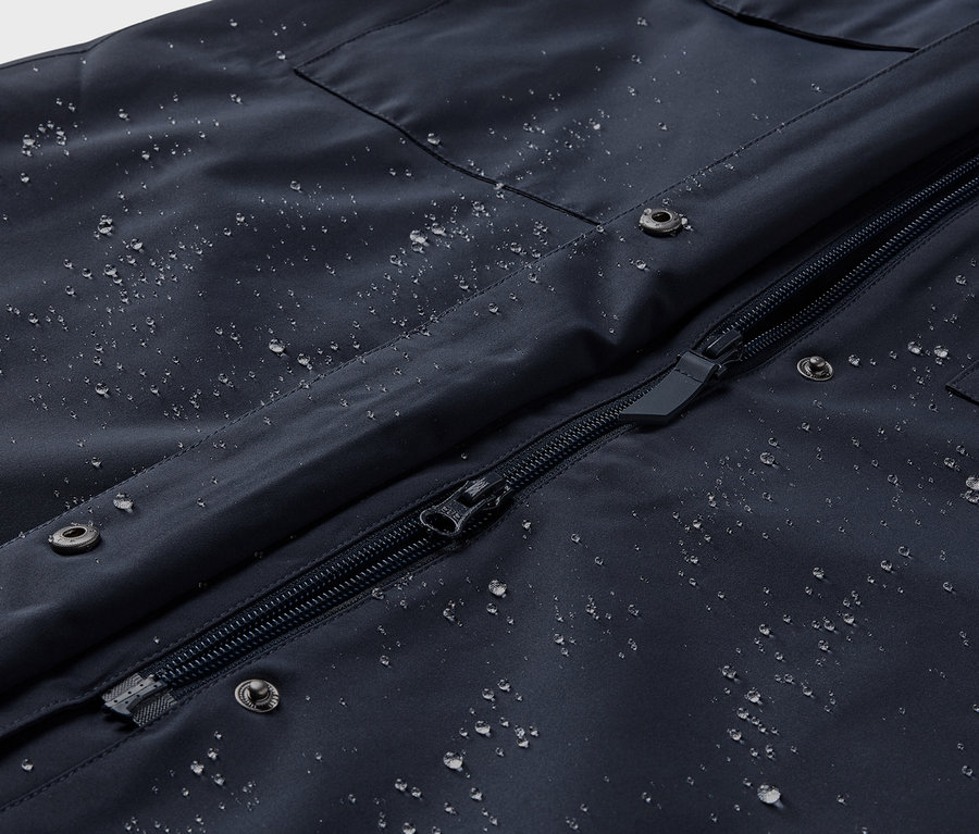 Nahaufnahme eines Regentrenchcoats mit Wassertropfen.