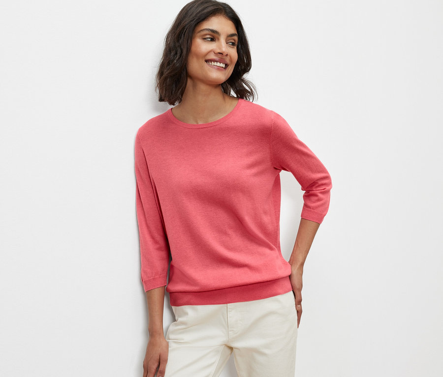 Frau posiert in Feinstrickpullover mit Seide, koralle.
