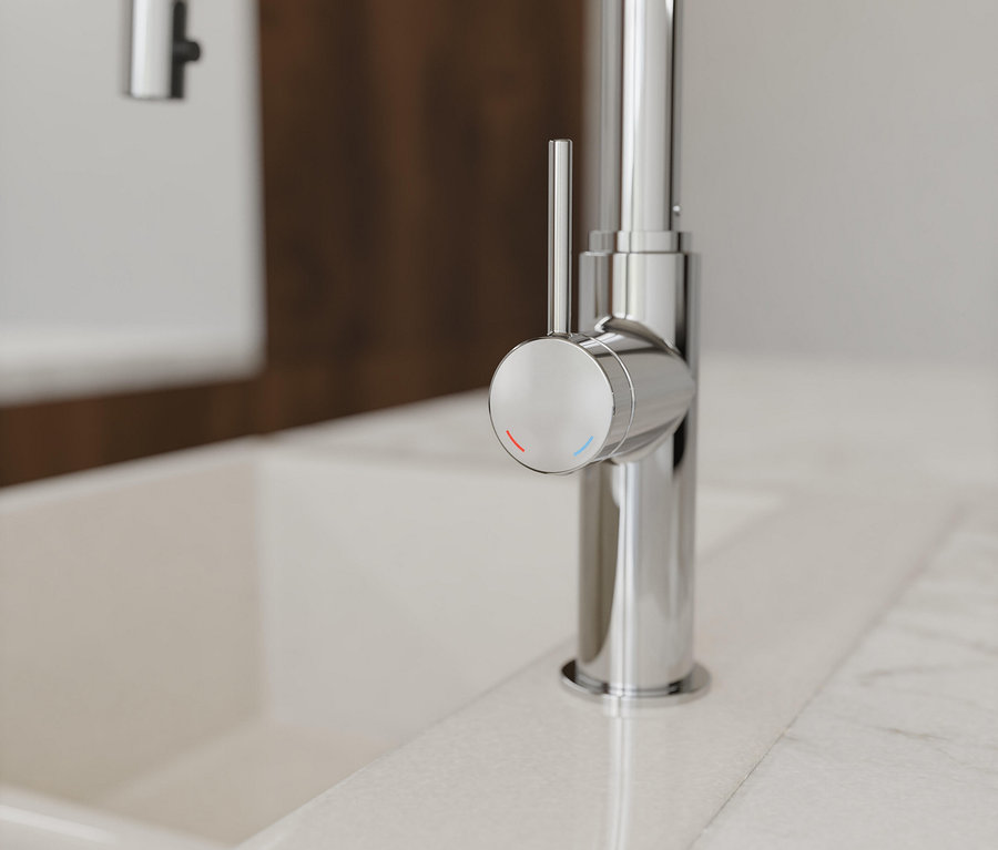 Detailaufnahme einer verchromten Armatur auf einem weißen Waschbecken.