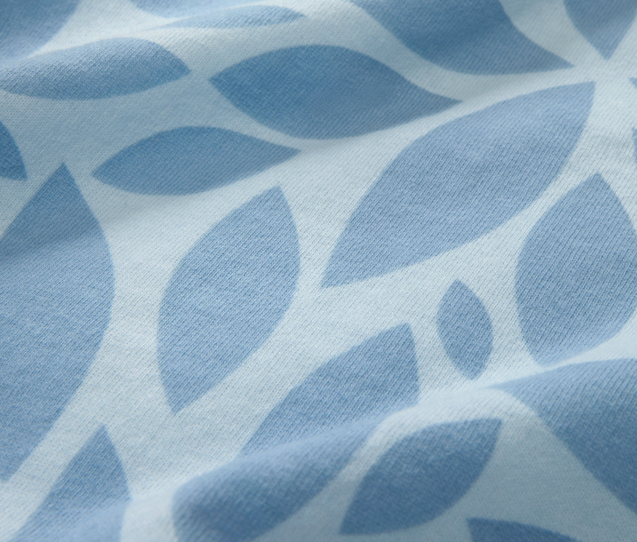 Detailansicht der hellblauen Winterjersey-Bettwäsche in Normalgröße mit Blattdruck.