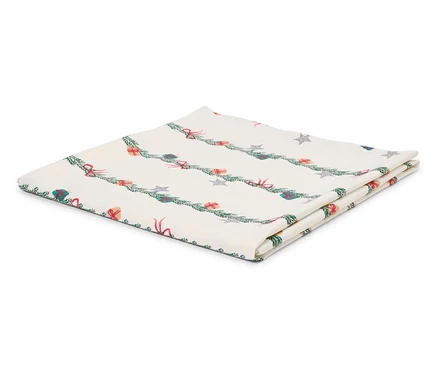 Gefaltete weiße Tischdecke mit weihnachtlichem Motiv aus Zweigen, Geschenken und Sternen.