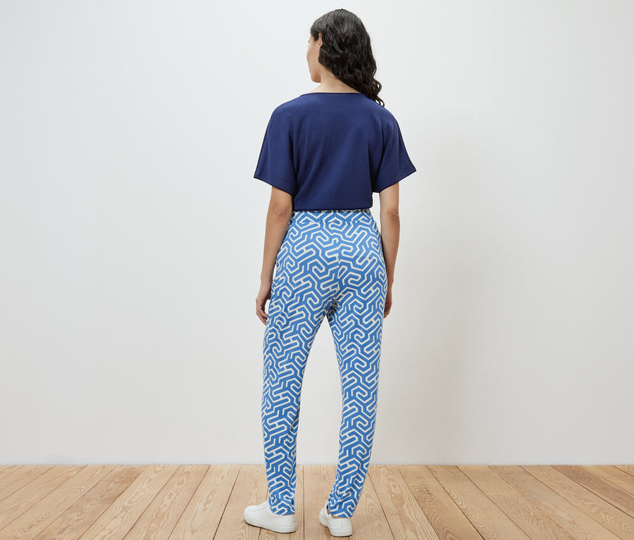 Frau von hinten trägt eine blaue bedruckte Jerseyhose.