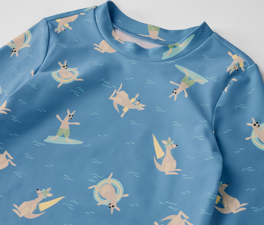 Blaues Kinder-Shirt mit UV-Schutzfaktor 80, bedruckt mit Kängurus, die surfen und im Meer schwimmen.
