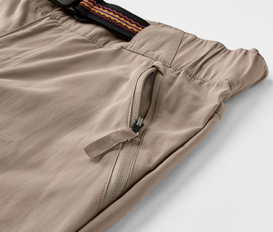 Detailaufnahme einer braunen Outdoorhose mit Moskito-Schutz und Reißverschlusstasche.