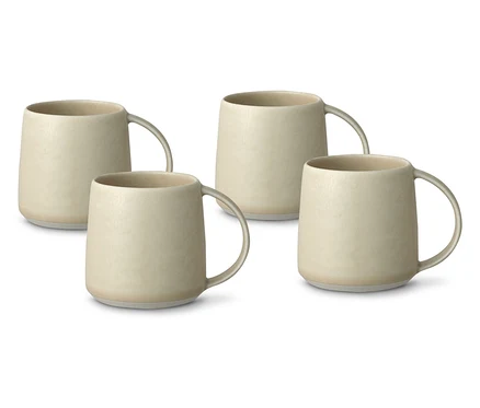 Vier beige Keramiktassen mit Henkeln stehen auf einem weißen Hintergrund.