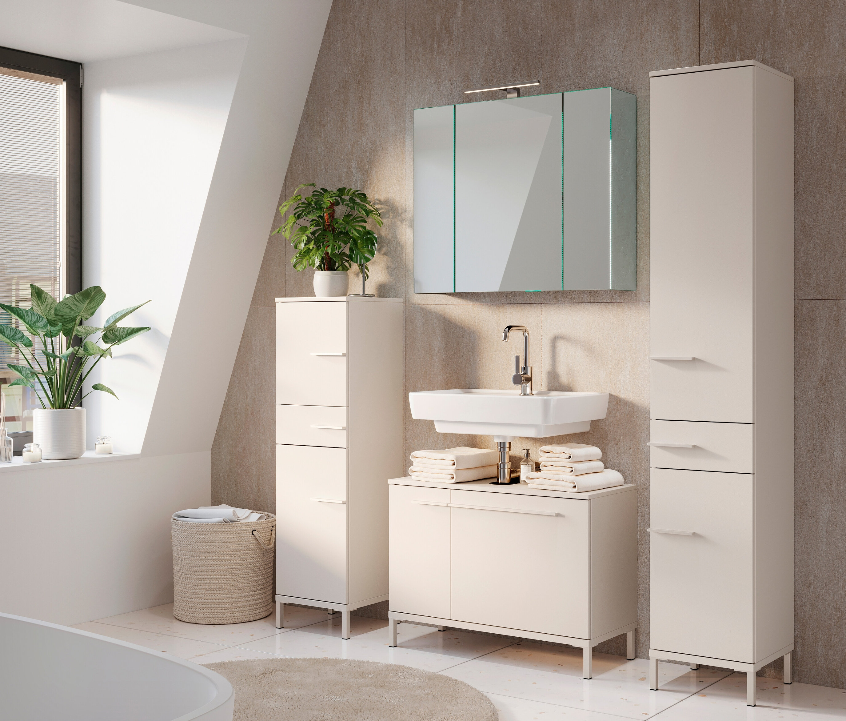 Ein Badezimmer mit einem großen Spiegelschrank »Tavira«, einem Waschbecken, zwei Hochschränken und Pflanzen.