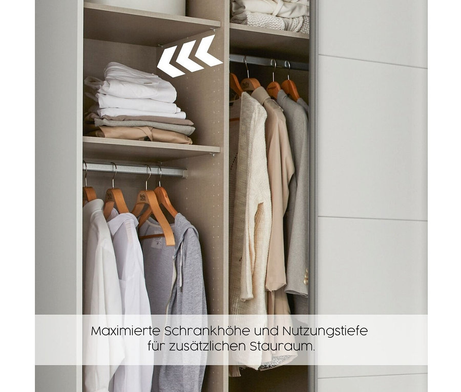 Offener rauch Drehtürenschrank »Butte« mit drei Türen zeigt Kleidung auf Holzbügeln und gefaltete Textilien auf Fachböden.