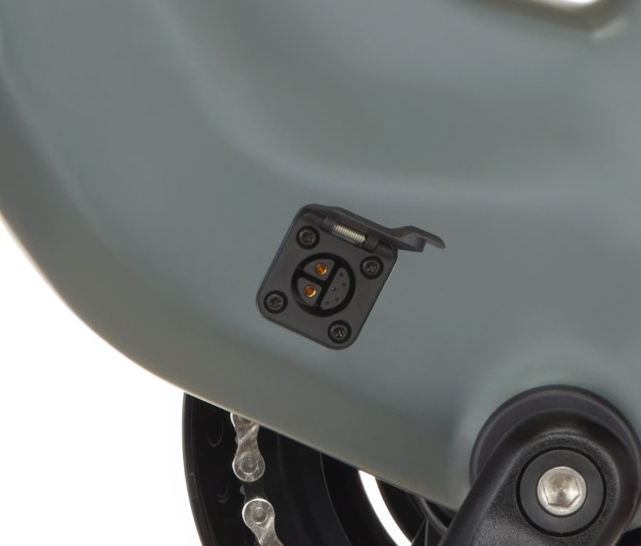 Nahaufnahme des Ladeanschlusses eines grauen FISCHER City E-Bike CITA MOVE am Rahmen, mit geöffneter Abdeckung.