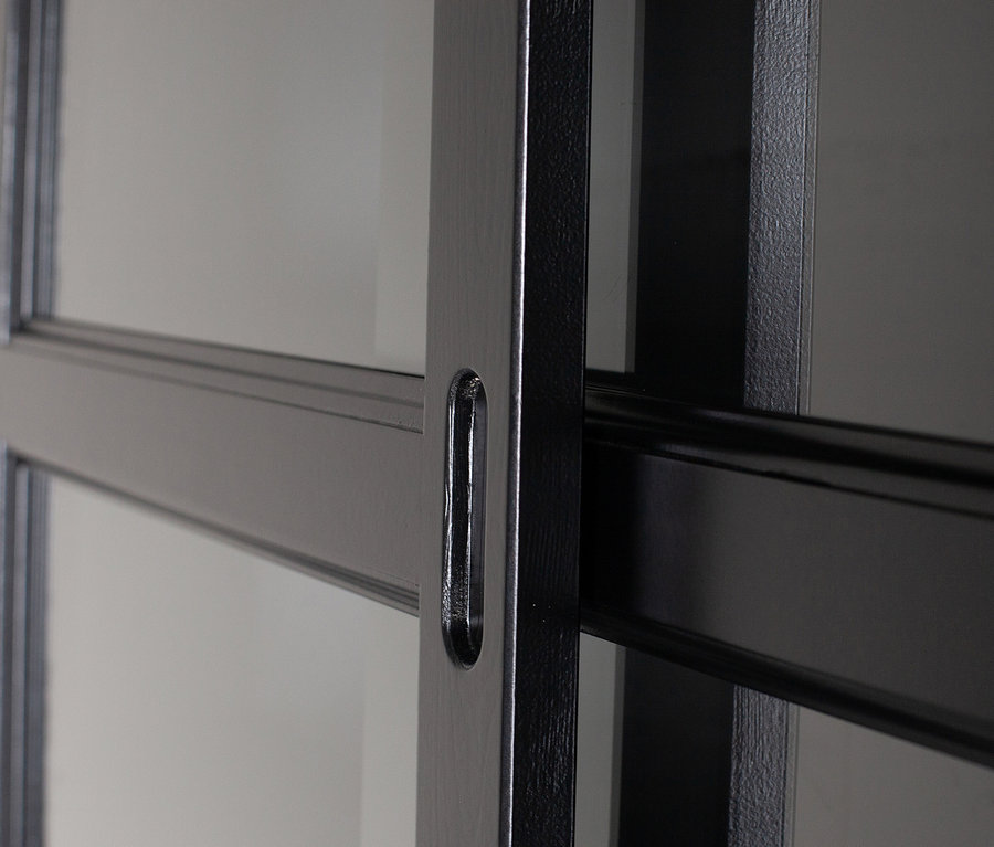 Detailansicht eines Woood »Lagos« Buffetschranks mit schwarzen Holzrahmen und Glasscheiben.