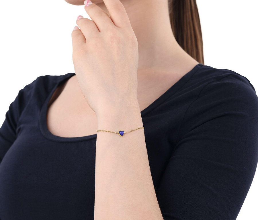 Frau trägt goldenes Amor Armband mit Herz-Motiv.
