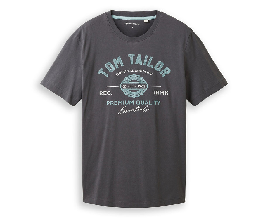 Ein graues T-Shirt mit blauem "Tom Tailor"-Aufdruck liegt flach auf einer weißen Oberfläche.