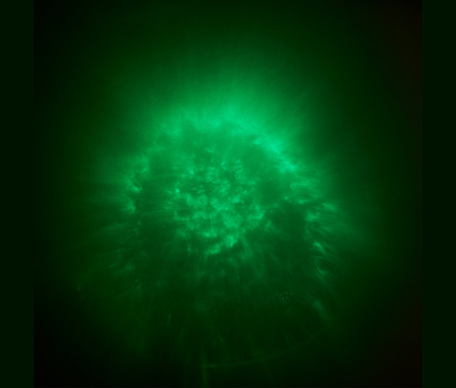 Grünes Licht mit einem diffusen Muster auf dunklem Hintergrund.
