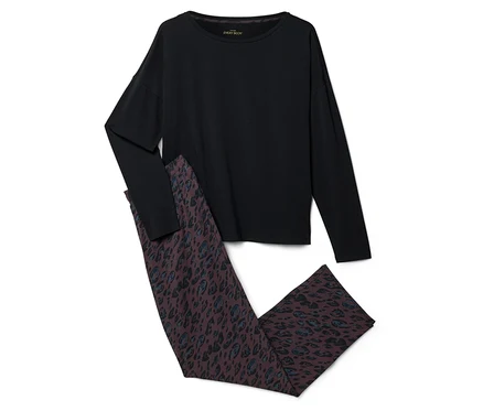 Ein schwarzes Langarmshirt und eine dunkelbraune Hose mit blau-schwarzem Leopardenmuster, flach auf weißem Hintergrund liegend.