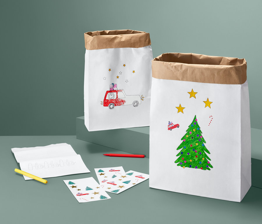 Zwei weisse Papiertüten aus dem Papiertüten-Bastel-Set mit weihnachtlichen Motiven.