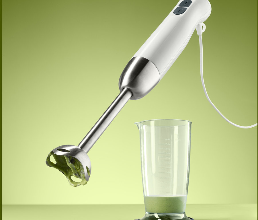 Ein Stabmixer über einem Glas mit Inhalt.