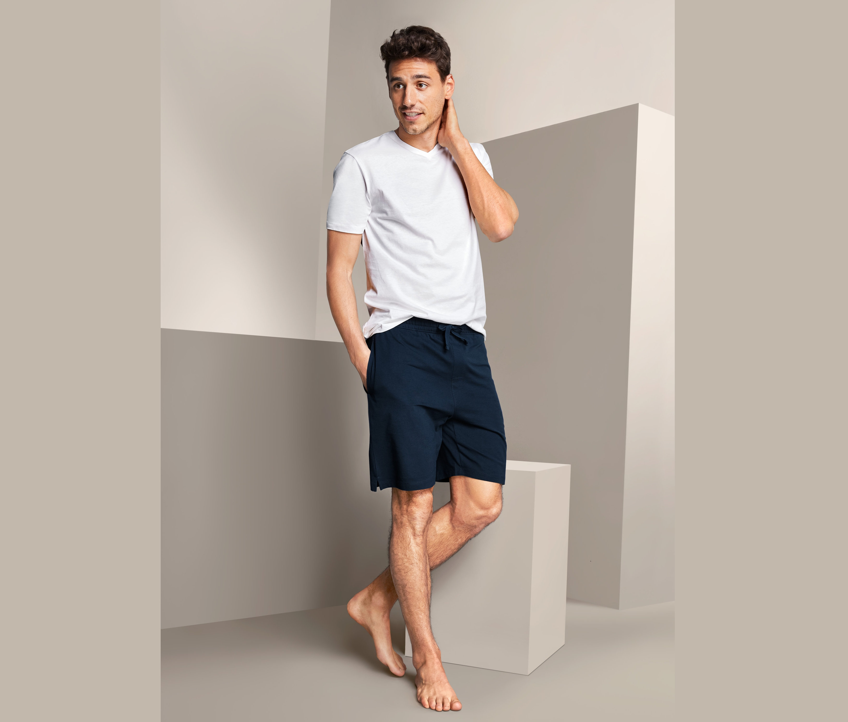 Mann posiert in Relaxhose und weißem T-Shirt.