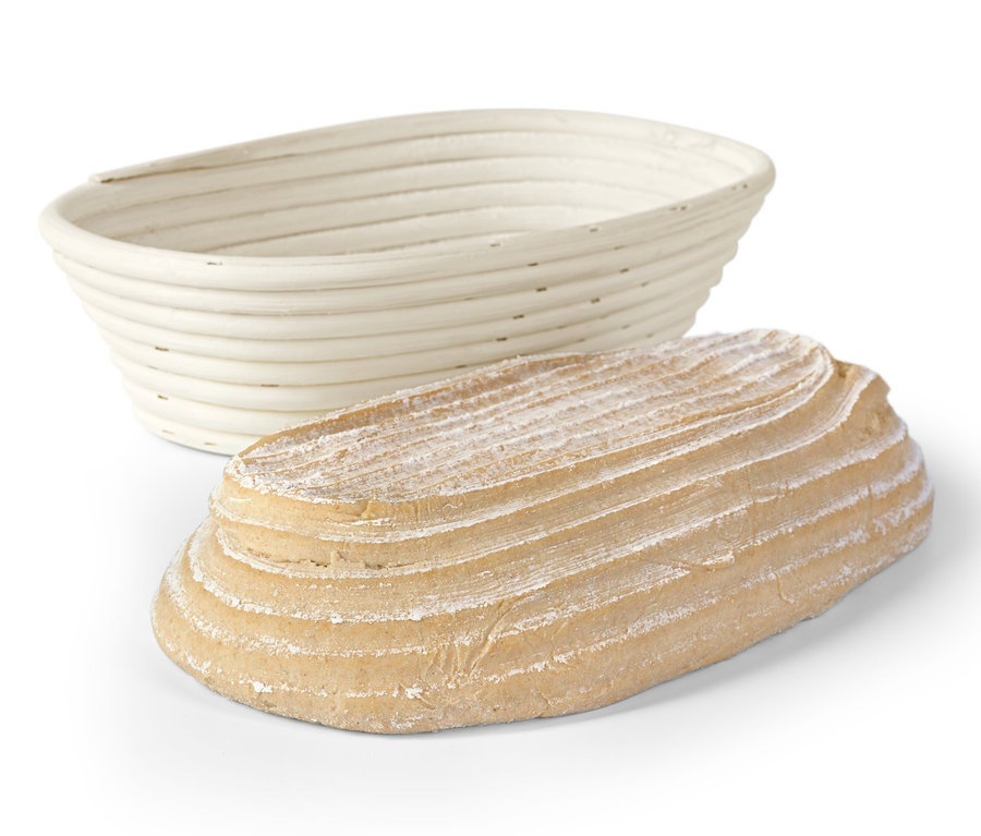 Ein ovales Gärkörbchen und ein gebackenes Brot.