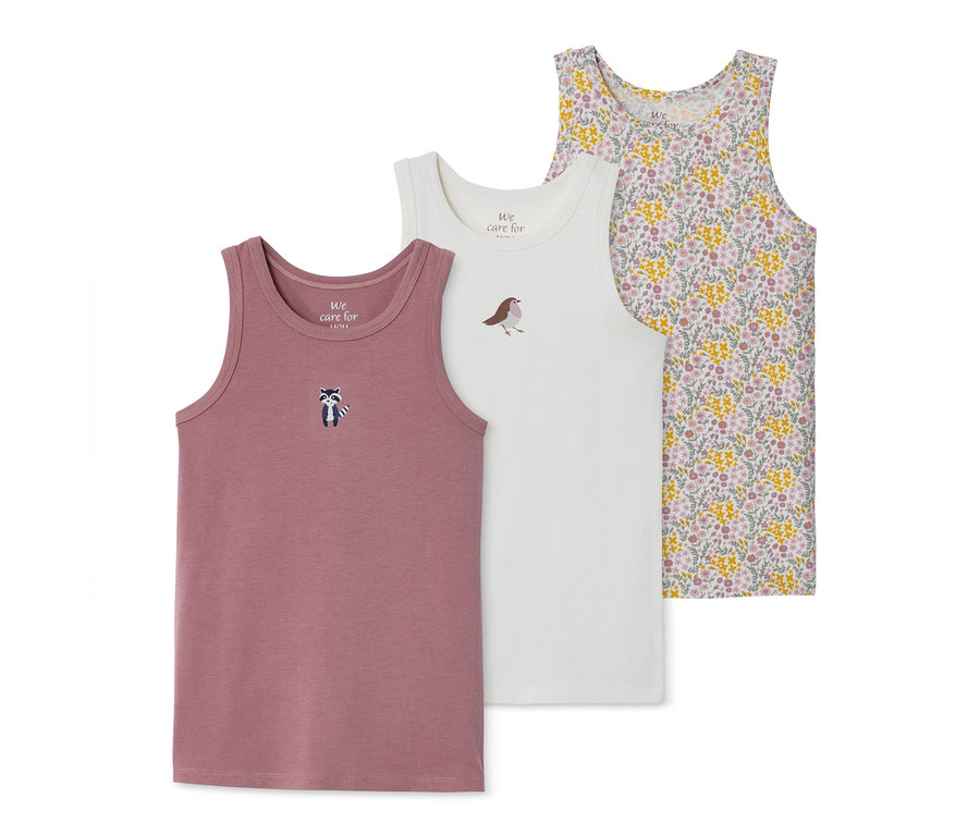 Drei Mädchen-Unterhemden: rosa mit Waschbär, weiß mit Vogel und geblümt.