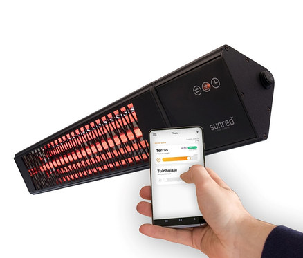 Eine Person bedient einen Sunred Wand-Heizstrahler »Professional Smart Heater Royal Diamond 2500 W« mit einem Mobiltelefon.
