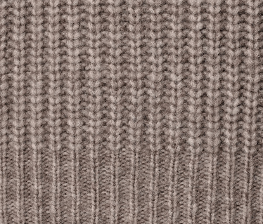 Detailaufnahme der Textur eines Grobstrick-Cardigans mit Wolle.