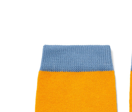 Zwei Kinder-Socken mit Bärenmotiv auf gelbem Hintergrund.