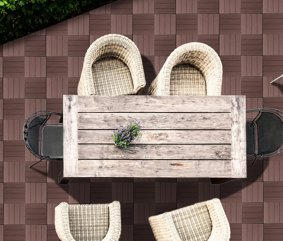 Draufsicht einer Terrasse mit braunen 30 x 30 cm WPC Terrassenfliesen, Holztisch, Blumen und Korbsesseln.