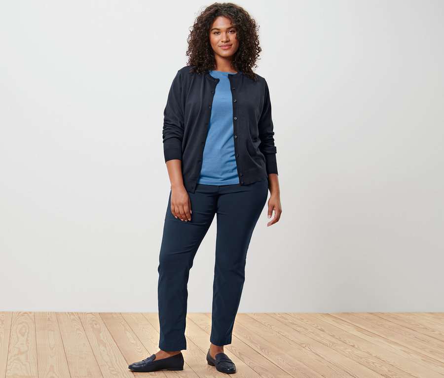 Frau trägt Feinstrick-Cardigan, T-Shirt und Hose.