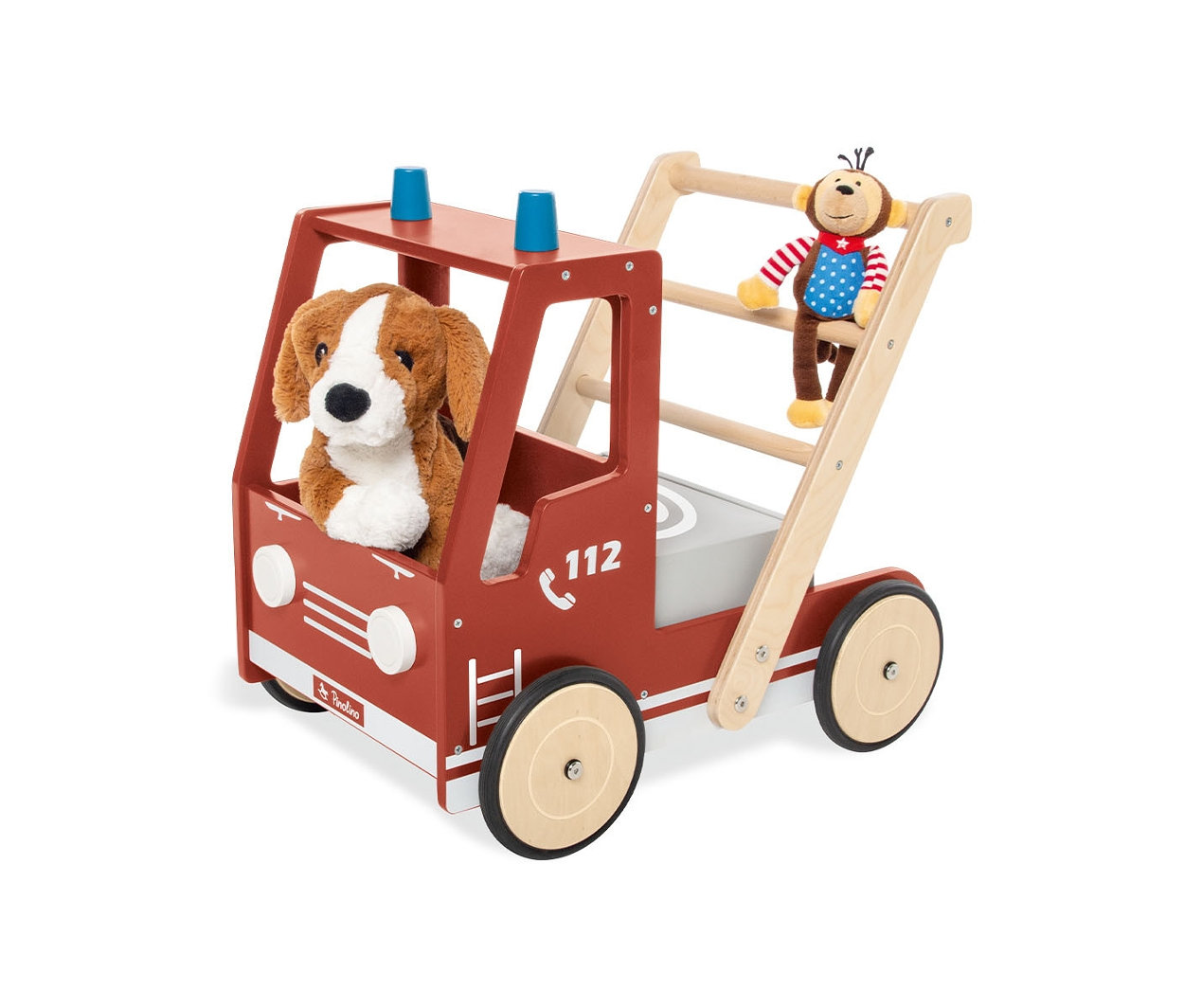 Ein Stoffhund sitzt im roten Pinolino Lauflernwagen »Feuerwehrauto Fred«, während ein Stoffaffe an der Leiter hängt.