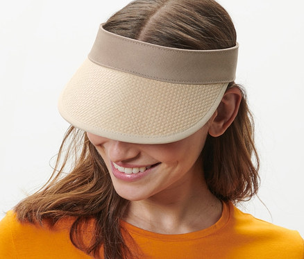 Eine lächelnde Frau trägt ein orangefarbenes Kleid und einen Sonnenvisor.