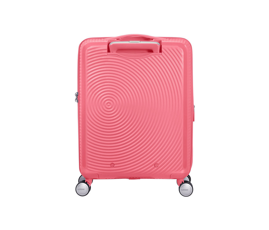 Detailaufnahme eines kleinen, sonnengeküssten korallenroten American Tourister Hartschalenkoffers »Soundbox« Spinner.