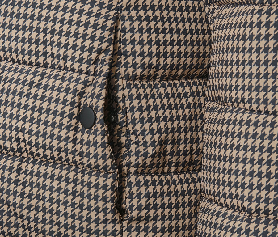Detailansicht einer bedruckten Steppjacke mit Kapuze im Hahnentrittmuster.