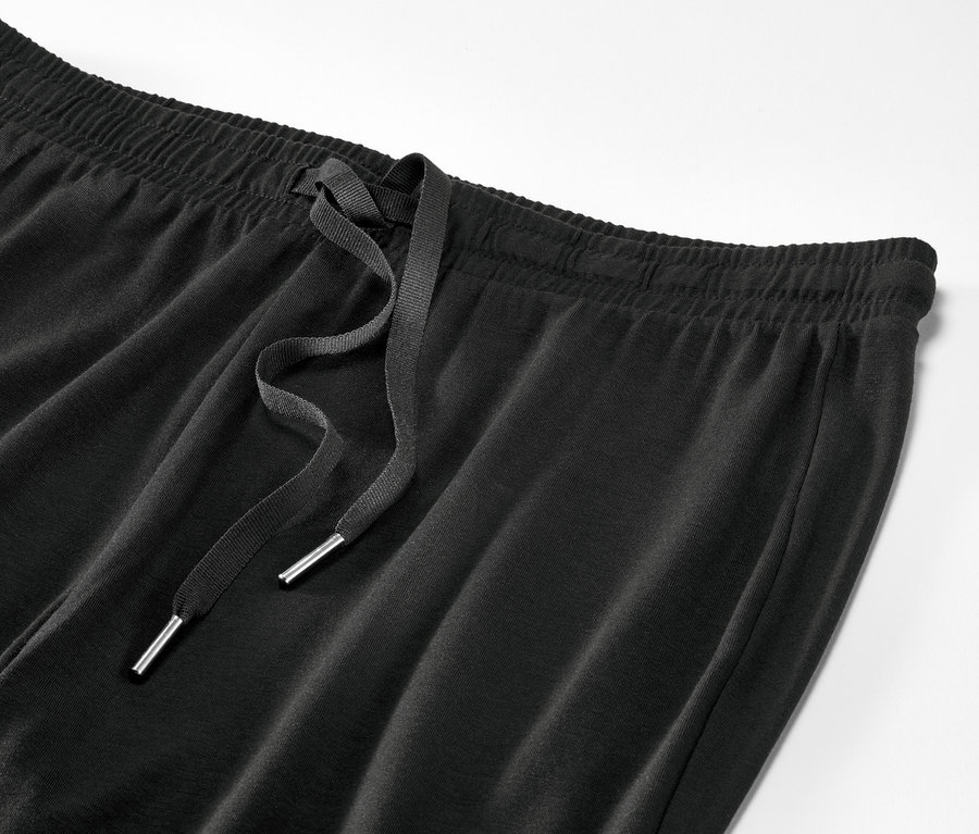 Detailaufnahme einer schwarzen Pyjamahose mit Kordelzug.