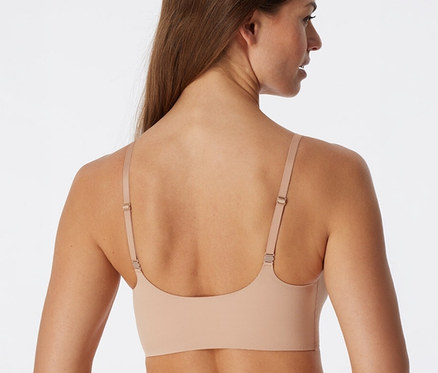 Frau von hinten in einem ahornfarbenen SCHIESSER Invisible Bustier mit Pads.