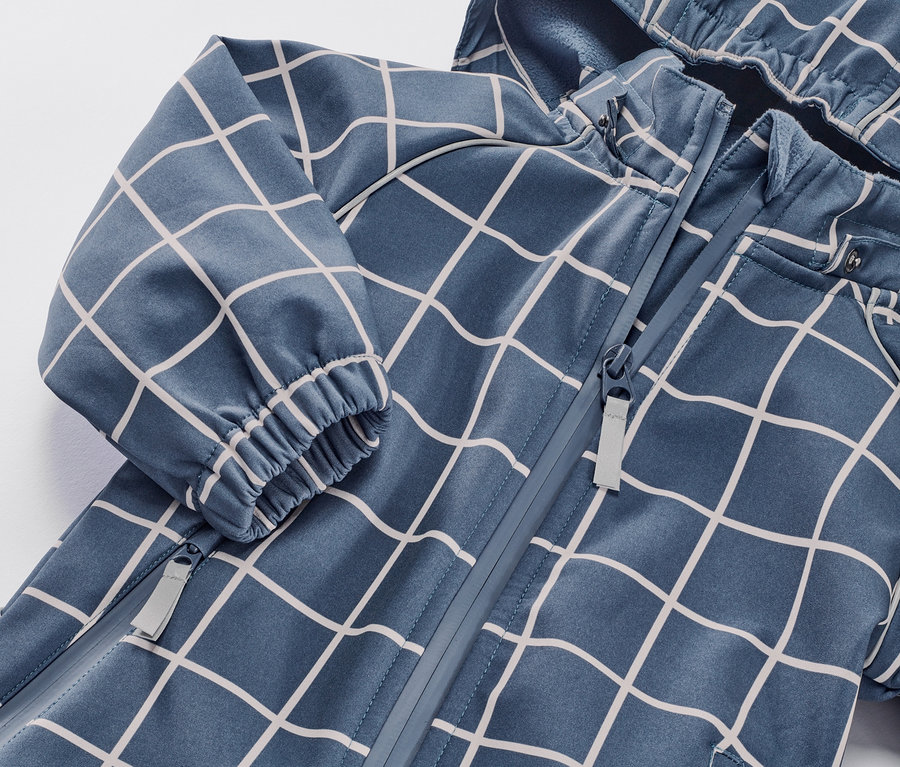 Detailansicht eines karierten Kleinkind-Softshell-Einteilers mit Reißverschluss.