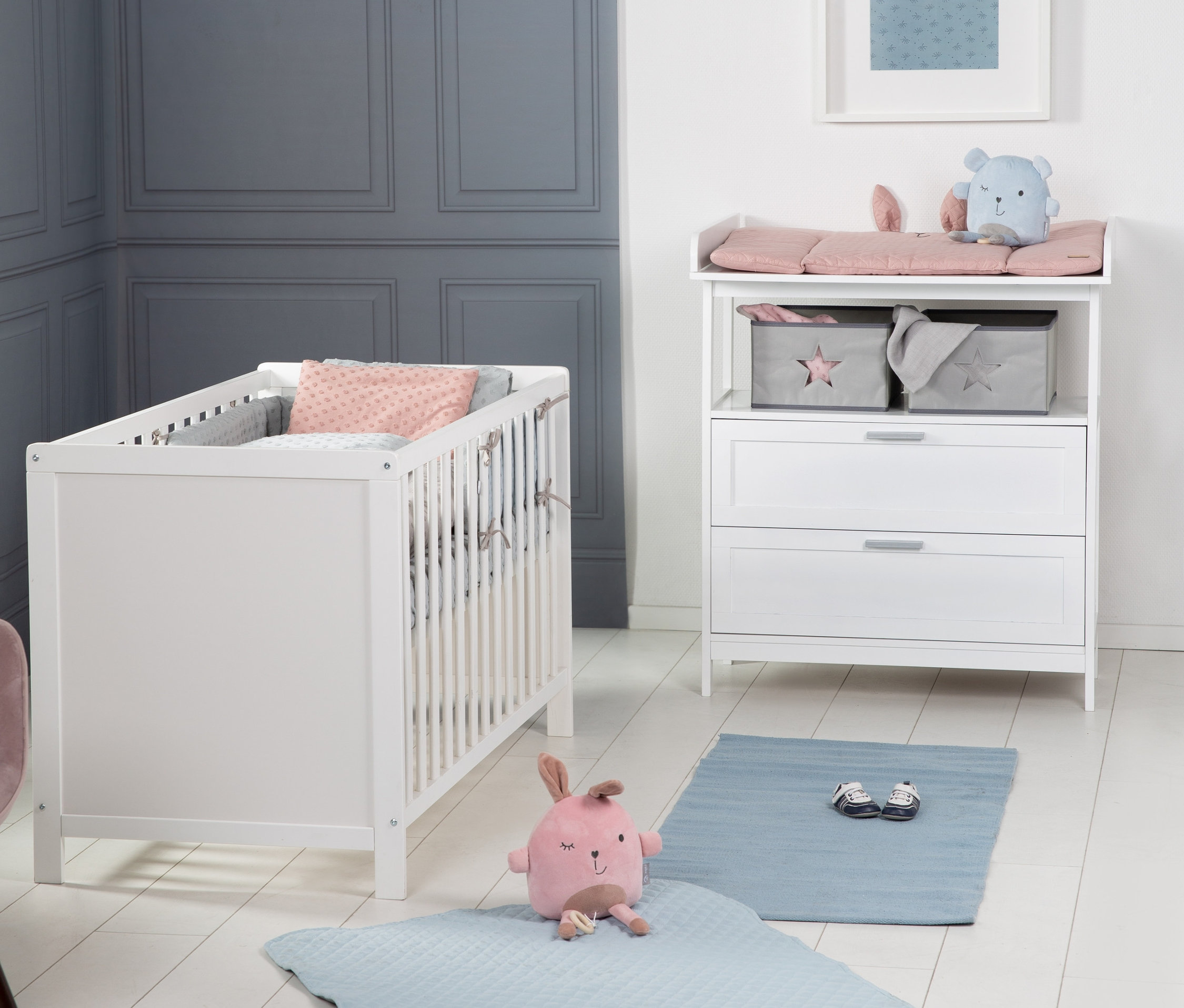 Kinderzimmer mit roba Kinderzimmer-Set, bestehend aus weißem Bett und Kommode. Blauer Teppich und Stofftier auf dem Boden.